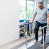 stroke-rehabilitation-mobility-independence Physiotherapist helping a stroke patient improve walking and mobility during rehabilitation